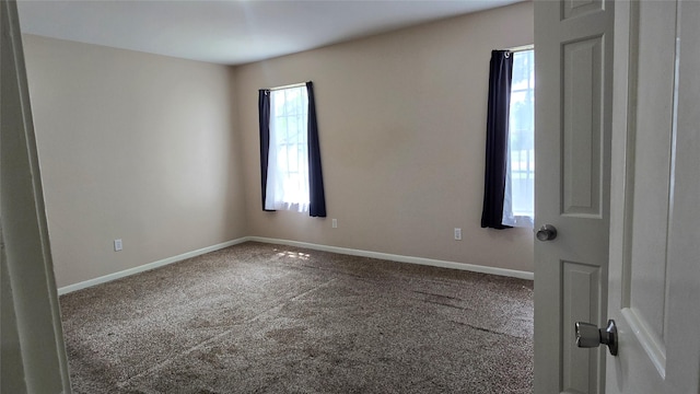 carpeted spare room featuring baseboards