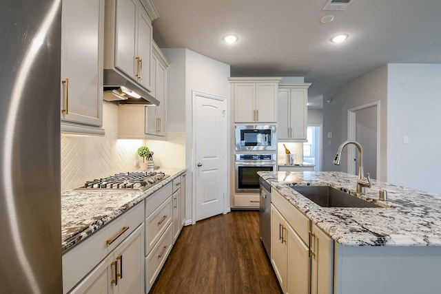 209 Cambria Green Ln, Katy, TX 77493 - kitchen with a sink, appliances with stainless steel finishes, under cabinet range hood, dark wood-style flooring, and decorative backsplash