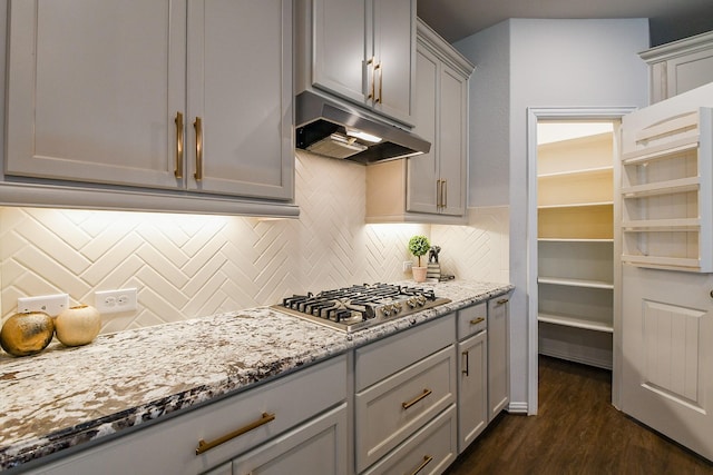 209 Cambria Green Ln, Katy, TX 77493 - kitchen with gray cabinets, under cabinet range hood, stainless steel gas stovetop, dark wood-style floors, and light stone counters
