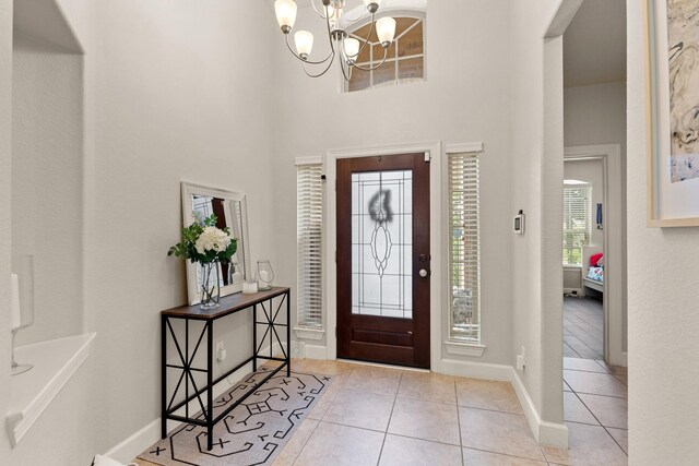 17222 Fable Springs Ln, Cypress, TX 77433 - foyer entrance with a chandelier, tile patterned flooring, baseboards, and a towering ceiling
