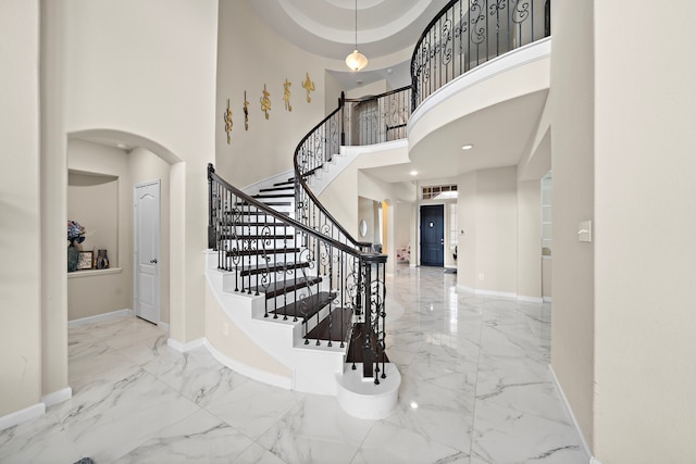 3627 Grand Promenade Ln, Stafford, TX 77477 - entrance foyer featuring marble tiled floors, baseboards, arched walkways, stairway, and a high ceiling