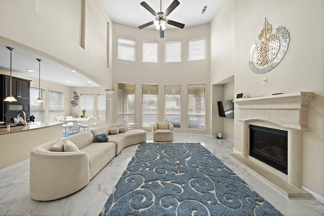 3627 Grand Promenade Ln, Stafford, TX 77477 - living room featuring marble tiled flooring, ceiling fan, baseboards, and a high ceiling