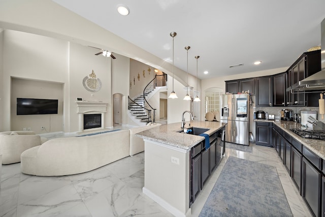 3627 Grand Promenade Ln, Stafford, TX 77477 - kitchen featuring stainless steel refrigerator with ice dispenser, light marble finish floors, black gas cooktop, a sink, and light stone countertops