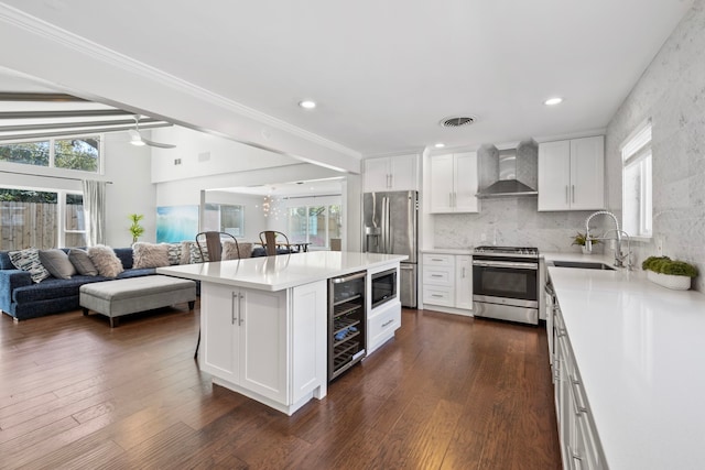 3531 Westridge St, Houston, TX 77025 - kitchen with appliances with stainless steel finishes, wall chimney range hood, beverage cooler, open floor plan, and ornamental molding