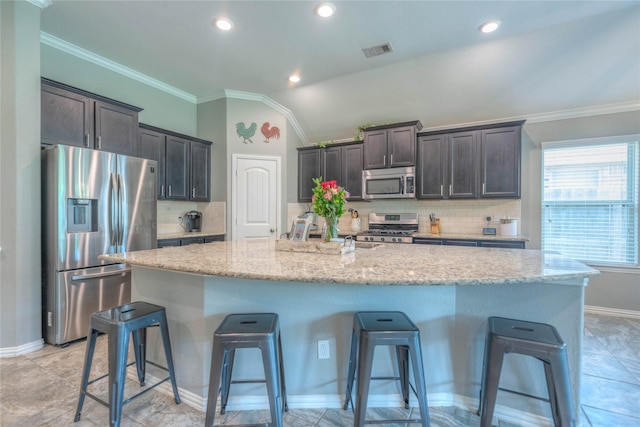 2255 Golden Laurel Dr, Conroe, TX 77304 - kitchen featuring stainless steel appliances, a breakfast bar area, tasteful backsplash, a large island, and vaulted ceiling