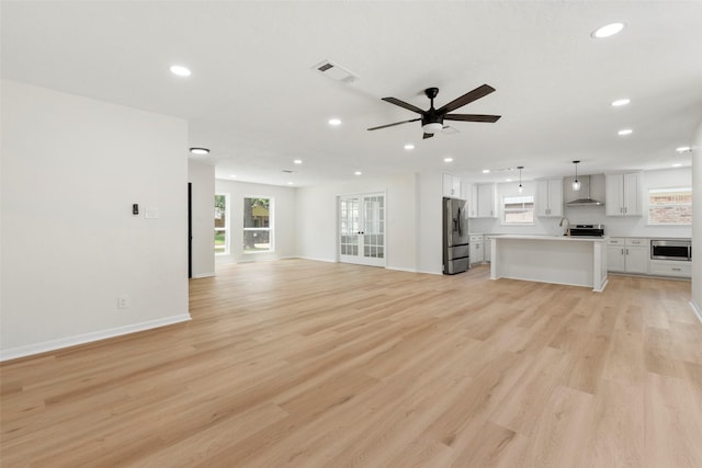 2610 Moss Hill Dr, Houston, TX 77080 - unfurnished living room featuring recessed lighting, light wood-style flooring, a ceiling fan, plenty of natural light, and baseboards