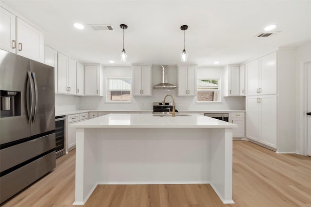2610 Moss Hill Dr, Houston, TX 77080 - kitchen featuring stainless steel refrigerator with ice dispenser, a sink, wall chimney range hood, wine cooler, and light wood finished floors