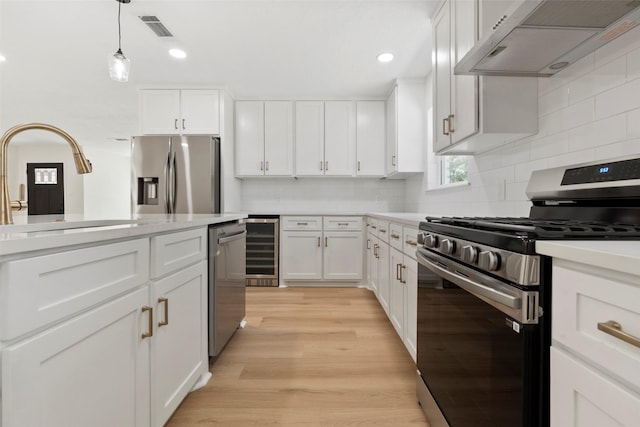 2610 Moss Hill Dr, Houston, TX 77080 - kitchen with stainless steel appliances, under cabinet range hood, beverage cooler, light countertops, and recessed lighting