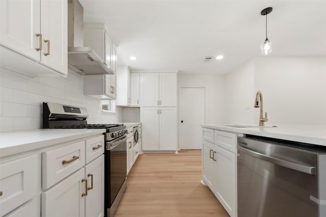 2610 Moss Hill Dr, Houston, TX 77080 - kitchen with stainless steel appliances, wall chimney exhaust hood, a sink, white cabinets, and backsplash