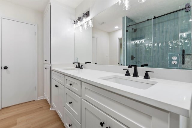 2610 Moss Hill Dr, Houston, TX 77080 - bathroom with a stall shower, wood finished floors, and double vanity
