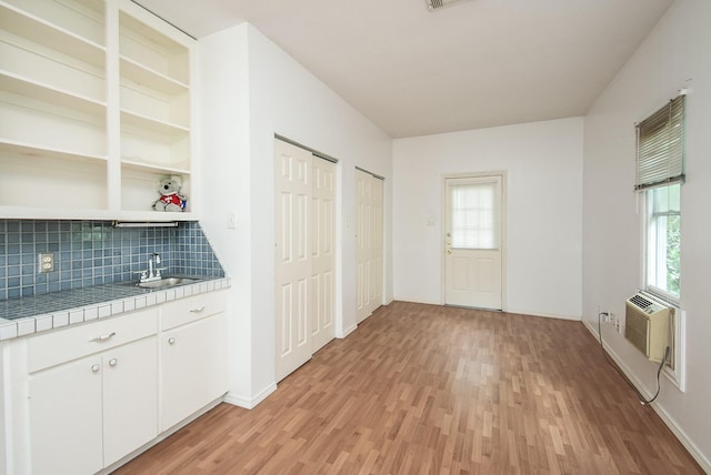 117 E 25th St, Houston, TX 77008 - kitchen featuring tile counters, light wood-style floors, tasteful backsplash, and open shelves