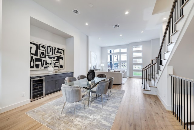2105 Emancipation Ave, Houston, TX 77003 - dining space with beverage cooler, a bar, light wood finished floors, stairway, and baseboards