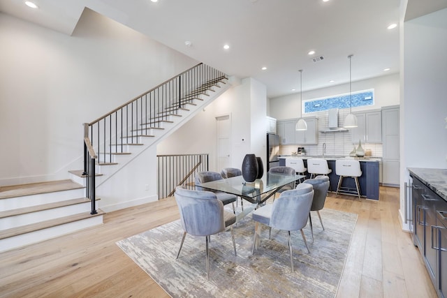 2105 Emancipation Ave, Houston, TX 77003 - dining area featuring light wood-style flooring, recessed lighting, stairs, and a high ceiling