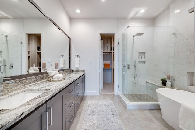 2105 Emancipation Ave, Houston, TX 77003 - bathroom featuring a stall shower, a freestanding bath, double vanity, tile patterned floors, and a spacious closet