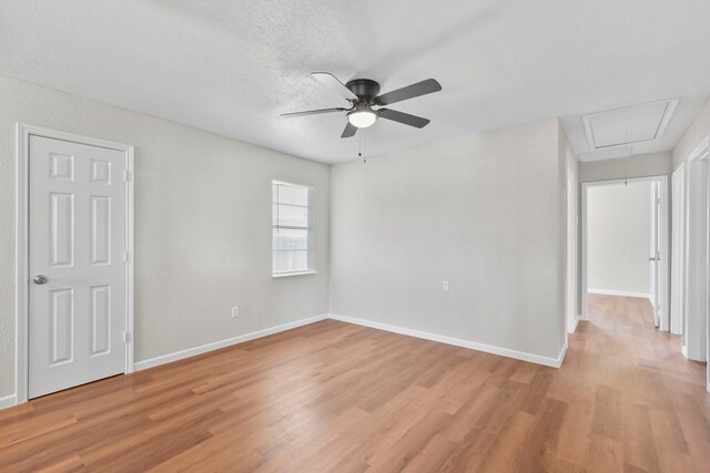 3221 Hage St, Houston, TX 77093 - spare room with attic access, light wood finished floors, a ceiling fan, baseboards, and a textured ceiling