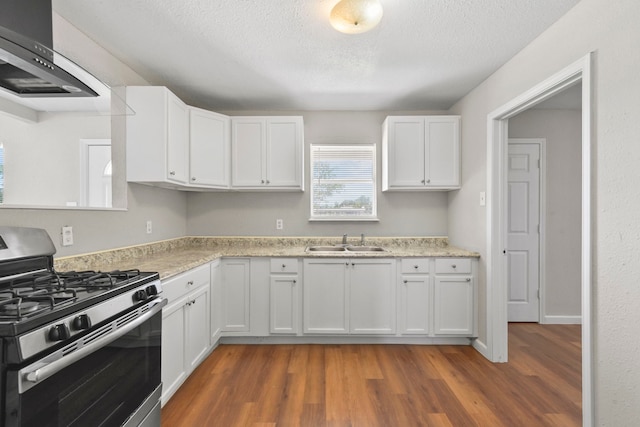 3221 Hage St, Houston, TX 77093 - kitchen with stainless steel gas range oven, a sink, ventilation hood, wood finished floors, and white cabinets