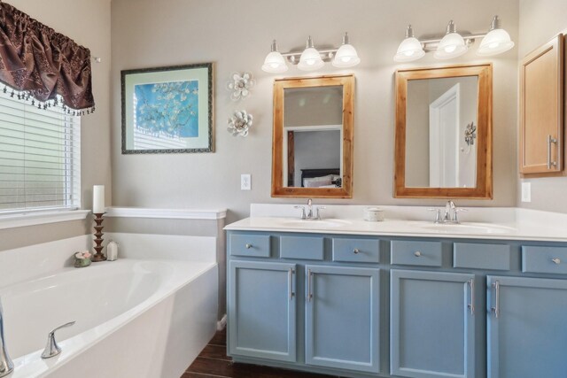 14039 Pawnee Bend Dr, Cypress, TX 77429 - bathroom with a bath, double vanity, and wood finished floors