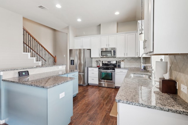 14039 Pawnee Bend Dr, Cypress, TX 77429 - kitchen with stainless steel appliances, a sink, light stone counters, dark wood finished floors, and recessed lighting