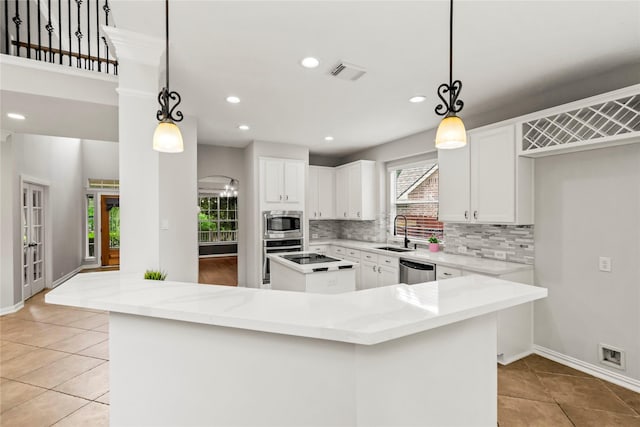 kitchen featuring a sink, a kitchen island, stainless steel appliances, backsplash, and light tile patterned floors