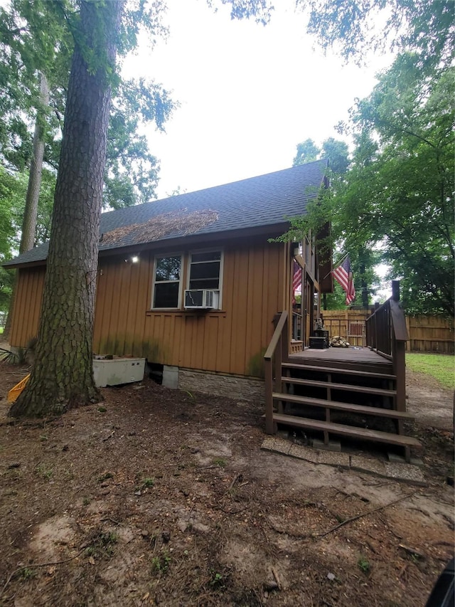 20 Shannon St, Huntsville, TX 77320 - rear view of property featuring a shingled roof, board and batten siding, a wooden deck, and cooling unit