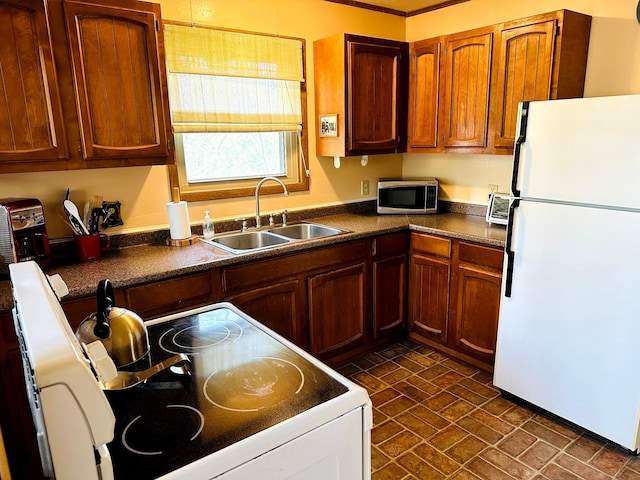 20 Shannon St, Huntsville, TX 77320 - kitchen featuring white appliances, a sink, dark countertops, and brown cabinetry