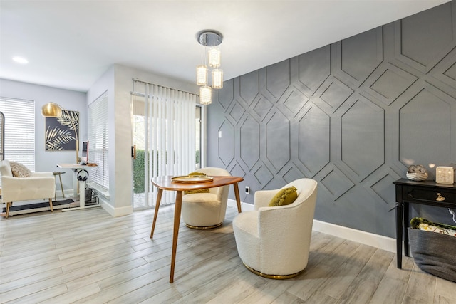 8051 Bay Branch Dr Unit 324, The Woodlands, TX 77382 - living area featuring baseboards, light wood-type flooring, and a decorative wall