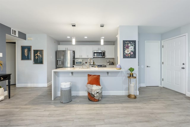 8051 Bay Branch Dr Unit 324, The Woodlands, TX 77382 - kitchen featuring appliances with stainless steel finishes, baseboards, light countertops, white cabinetry, and recessed lighting