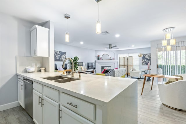8051 Bay Branch Dr Unit 324, The Woodlands, TX 77382 - kitchen featuring a sink, a peninsula, light countertops, white cabinets, and dishwasher