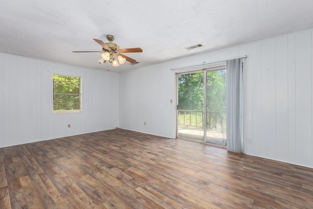 126 Cris Rd, Lufkin, TX 75901 - empty room with wood finished floors, plenty of natural light, ceiling fan, and wooden walls