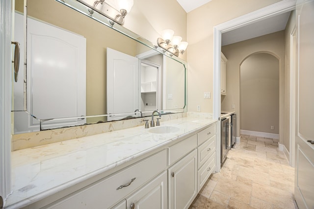 2119 Red Bird Ln, Brookshire, TX 77423 - bathroom with stone tile floors, vanity, wine cooler, and baseboards