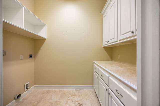 2119 Red Bird Ln, Brookshire, TX 77423 - laundry area featuring hookup for an electric dryer, baseboards, stone tile floors, washer hookup, and cabinet space