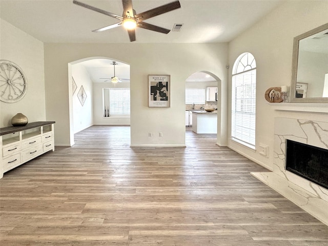 9630 E Withers Way Cir, Houston, TX 77065 - unfurnished living room with ceiling fan, arched walkways, plenty of natural light, and a high end fireplace
