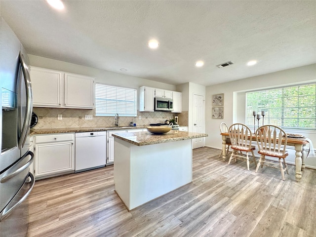 9630 E Withers Way Cir, Houston, TX 77065 - kitchen featuring appliances with stainless steel finishes, a sink, light wood finished floors, backsplash, and recessed lighting