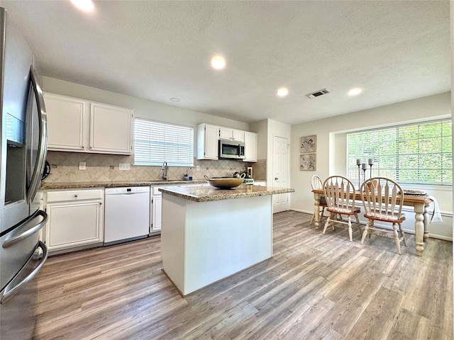 9630 E Withers Way Cir, Houston, TX 77065 - kitchen featuring appliances with stainless steel finishes, tasteful backsplash, light wood finished floors, white cabinets, and recessed lighting