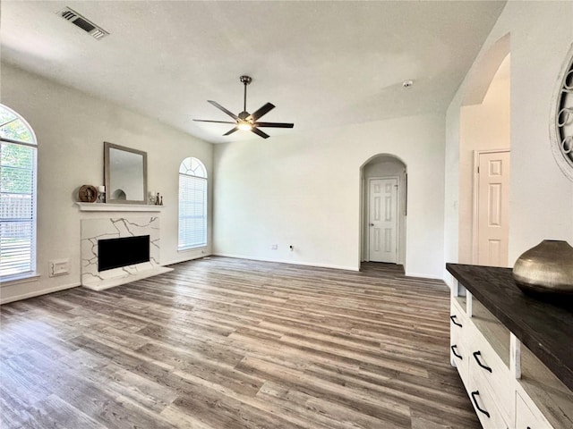 9630 E Withers Way Cir, Houston, TX 77065 - living room with a ceiling fan, arched walkways, wood finished floors, a high end fireplace, and baseboards