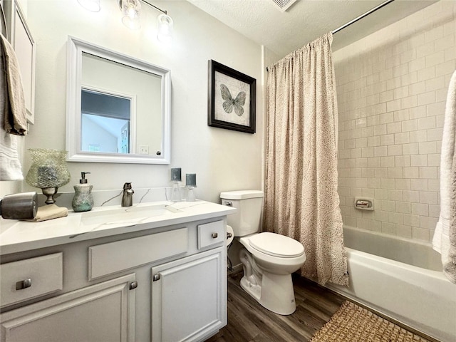 9630 E Withers Way Cir, Houston, TX 77065 - full bathroom with wood finished floors, toilet, vanity, shower / bath combo with shower curtain, and a textured ceiling