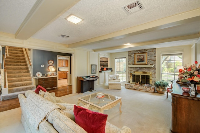 5410 Coral Ridge Rd, Houston, TX 77069 - living area featuring beamed ceiling, stairs, a textured ceiling, and a fireplace