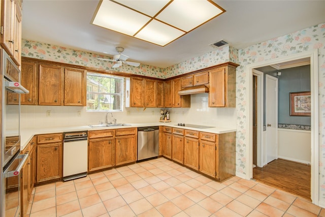 5410 Coral Ridge Rd, Houston, TX 77069 - kitchen with appliances with stainless steel finishes, a sink, wallpapered walls, light countertops, and brown cabinetry
