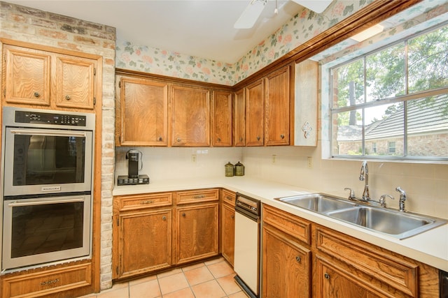 5410 Coral Ridge Rd, Houston, TX 77069 - kitchen with stainless steel double oven, a sink, healthy amount of natural light, wallpapered walls, and light countertops