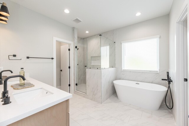 3312 Bremond St, Houston, TX 77004 - full bathroom with a freestanding bath, marble finish flooring, a marble finish shower, recessed lighting, and tile walls