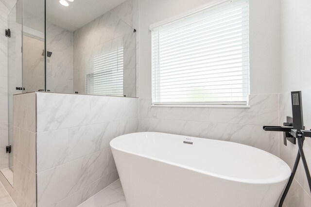 3312 Bremond St, Houston, TX 77004 - full bath featuring a shower stall, tile walls, a freestanding tub, and marble finish flooring