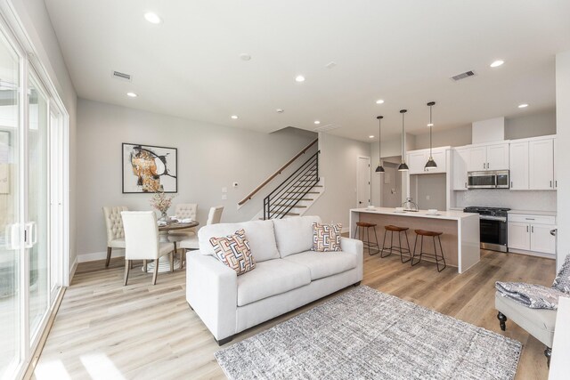 3312 Bremond St, Houston, TX 77004 - living area featuring stairs, light wood finished floors, recessed lighting, and baseboards