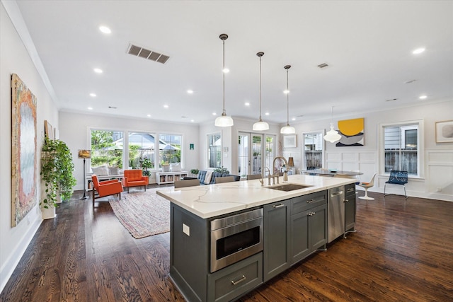 712 E 14th St, Houston, TX 77008 - kitchen featuring appliances with stainless steel finishes, gray cabinets, a sink, dark wood-style flooring, and a kitchen island with sink