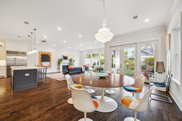 712 E 14th St, Houston, TX 77008 - dining space featuring dark wood-type flooring, a glass covered fireplace, baseboards, recessed lighting, and crown molding