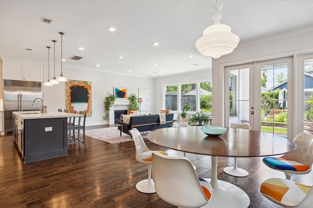 712 E 14th St, Houston, TX 77008 - dining space featuring a fireplace, crown molding, baseboards, dark wood-style flooring, and recessed lighting