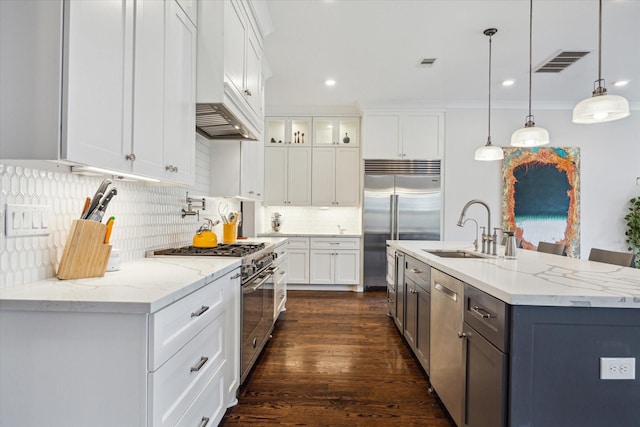 712 E 14th St, Houston, TX 77008 - kitchen featuring high end appliances, a sink, white cabinets, decorative backsplash, and hanging light fixtures