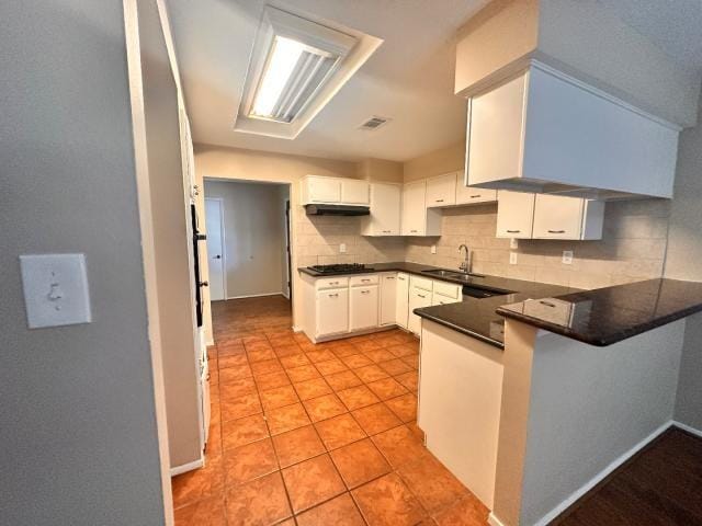 959 Reseda Dr, Houston, TX 77062 - kitchen with a peninsula, a sink, decorative backsplash, gas stovetop, and white cabinets