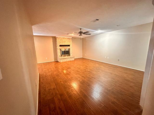 959 Reseda Dr, Houston, TX 77062 - unfurnished living room with ceiling fan, wood finished floors, a fireplace, and baseboards