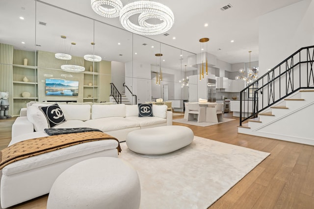 5820 Winsome Ln Unit B, Houston, TX 77057 - living room with a chandelier, stairway, light wood-style floors, built in features, and a towering ceiling