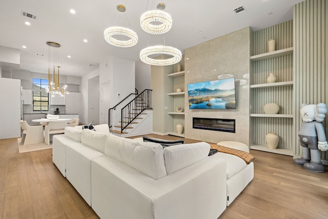 5820 Winsome Ln Unit B, Houston, TX 77057 - living area featuring built in shelves, light wood finished floors, a chandelier, stairway, and a large fireplace